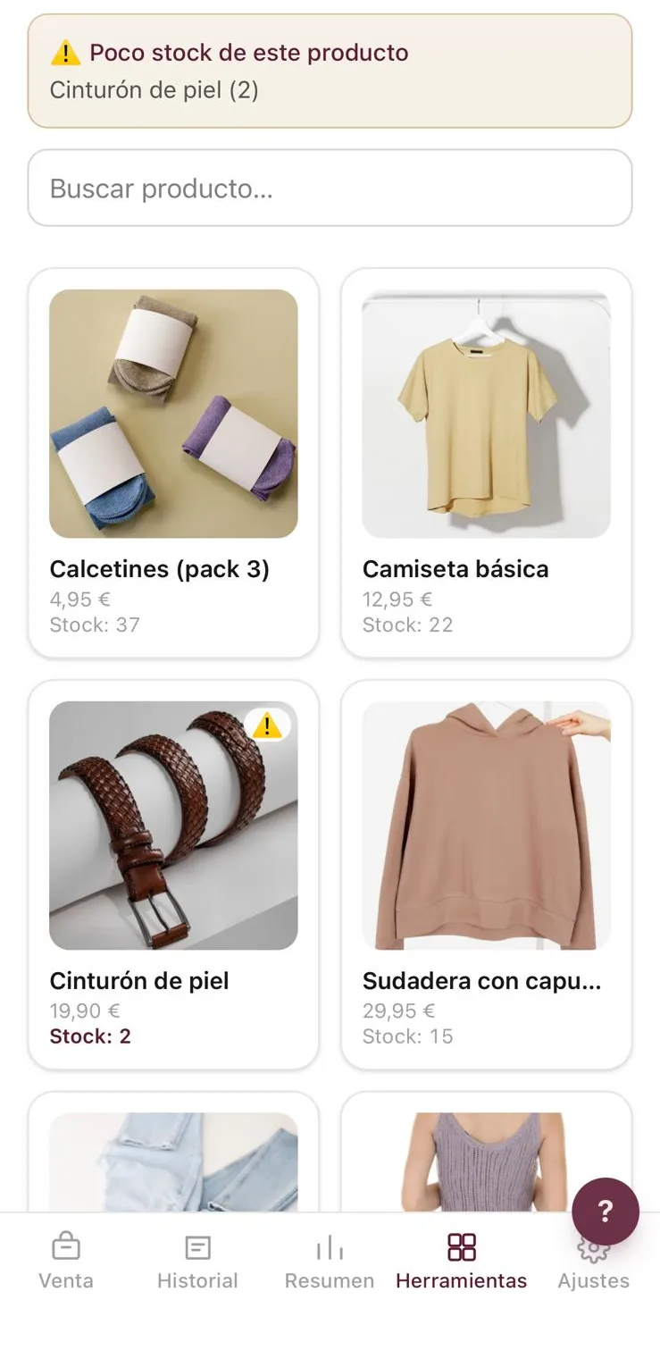 El inventario de TuFactu en un móvil: un aviso de poco stock del cinturón de piel, y debajo las prendas con su foto, su precio y las unidades que quedan.